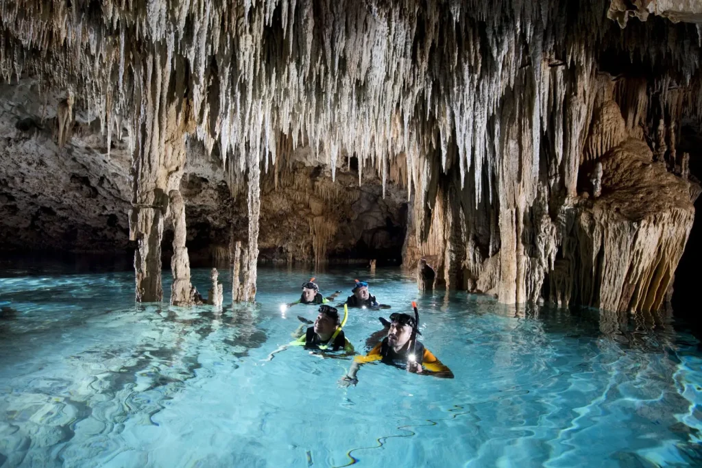 Underground cenote cave in Yucatán with stalactites and crystal-clear water