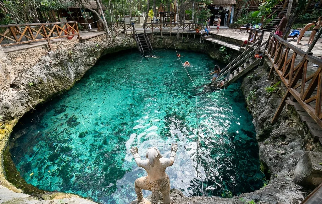 Cenote in Playa del Carmen surrounded by jungle with turquoise waters